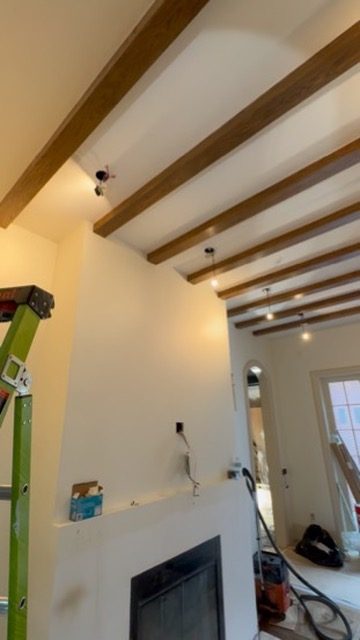 Lighting install in progress in a beamed ceiling in a Massachusetts home